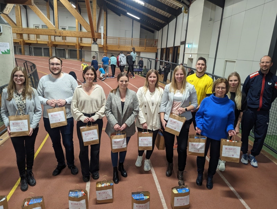 Seit fast zehn Jahren kooperiert das Kreisjugendamt Paderborn mit der Stiftung Lebenslauf und bringt Kinder und Jugendliche in schwierigen Lebenssituationen in Bewegung. Gesine Brumby (vorne rechts) nahm für die Stiftung die Tüten im Empfang und bedankte sich ebenso für die schönen Weihnachtsgeschenke: „Wir bringen Kinder in einen neun Monaten Intensivkurs in Bewegung. Sie sollen lernen: Wenn ich mich selbst bewege, kann ich meine Ziele erreichen“. Die Weihnachtsengel des Rotaract-Club waren tief beeindruckt von diesem Einblick hinter die Kulissen des präventiven Kindesschutzes: „Wir freuen uns sehr, dass wir mit unserer Arbeit den Kindern ein Lächeln ins Gesicht zaubern konnten“, war das einhellige Resümee von Marilena Koch, Lukas Reick und Lynn Brinkmann (von links). Das Trainergespann Julian Ahlemeyer, Lara-Sophie Wiemers, Sebastian Krüger ( hinten von rechts) und die sozialpädagogischen Begleiter Malin Bannert (4.v.l.), Vanessa Vielmeyer (5.vl.) und Lena Dirks (6.v.l.)  stoppten die Lebenslauf-Kinder für diesen vorweihnachtlichen Moment auf der Startbahn im Ahorn-Sportbahn und nahmen die Weihnachtstüten mit strahlenden Augen entgegen. Die Kinder nahmen direkt nach der Übergabe einen neuen Anlauf im Ahorn-Sportpark – mit noch mehr Freude!